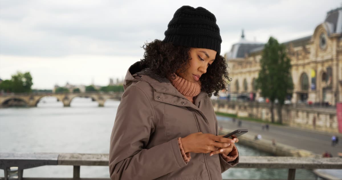 Young woman checking her mobile bank account in France